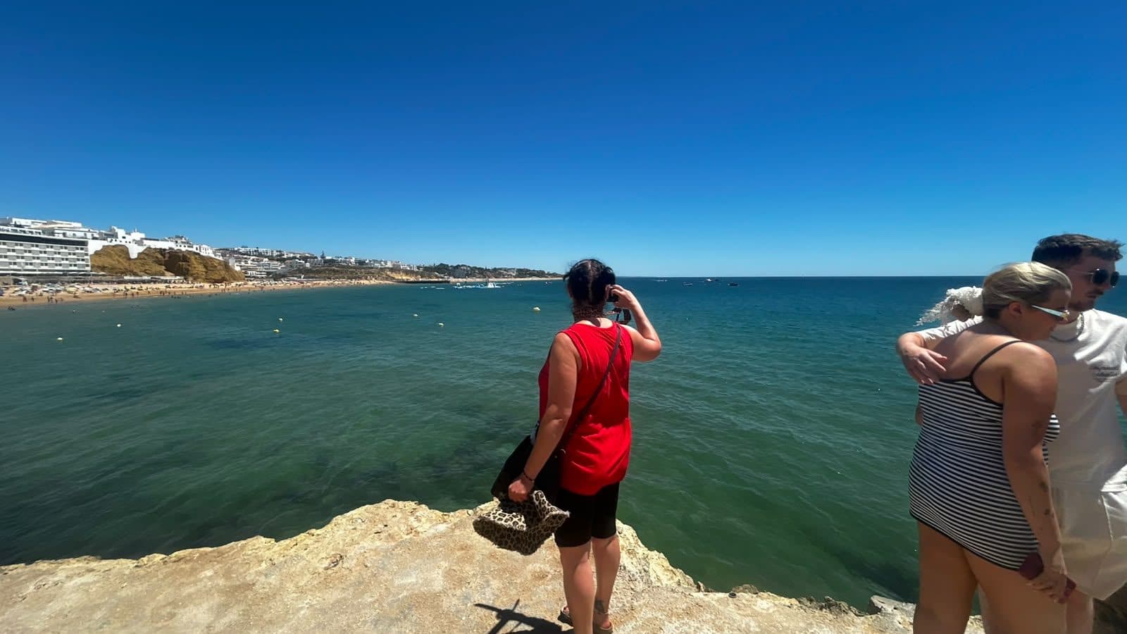 Tiago photographing guests on the rocks above the water in Albufeira